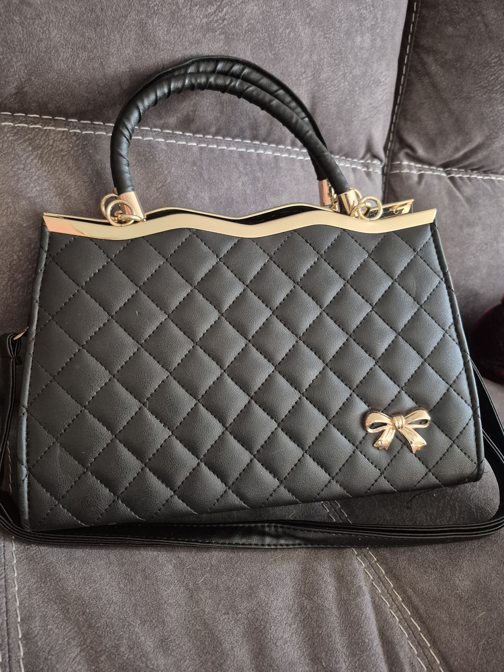 Elegant Black Quilted Top-Handle Bag with Gold Bow Accent